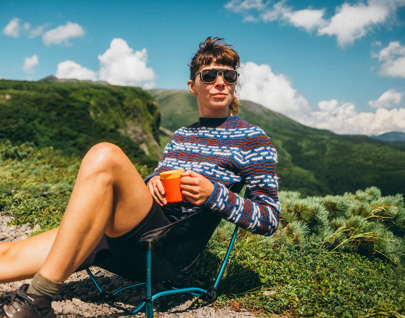 woman in sunski ferrata olive citrine amber drinking coffee in the mountains