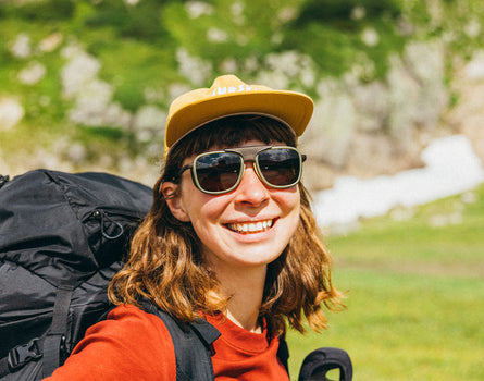 woman backpacking in the mountains wearing sunski ferrata olive citrine amber