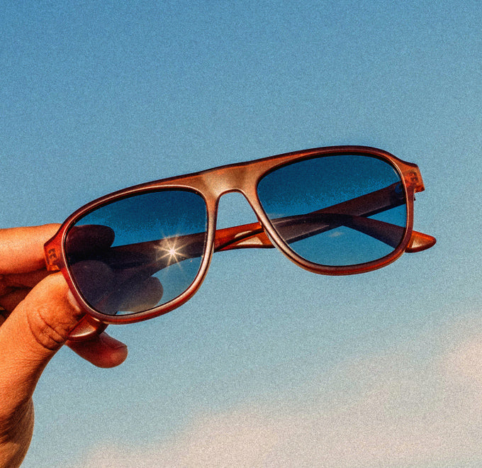 hand holding a pair of sunski shoreline sunglasses