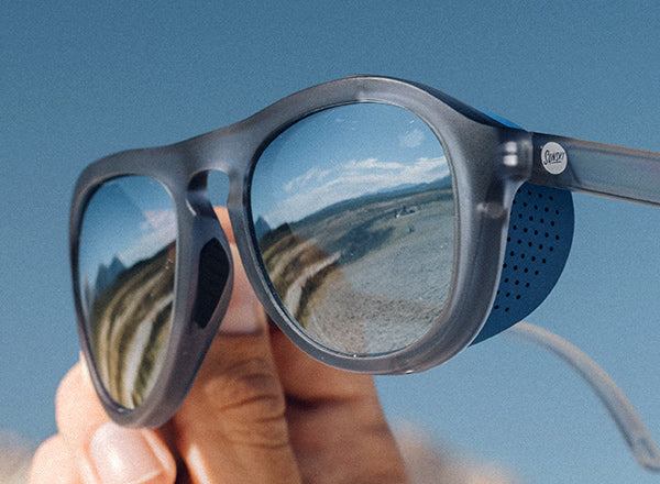 sunski treeline sunglasses being held in the air