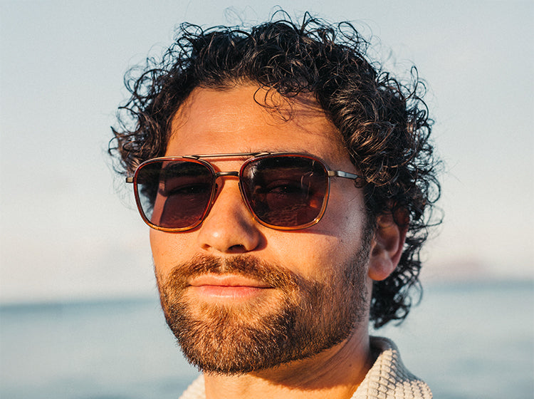 Man wearing sunski estero sunglasses with a blurred background