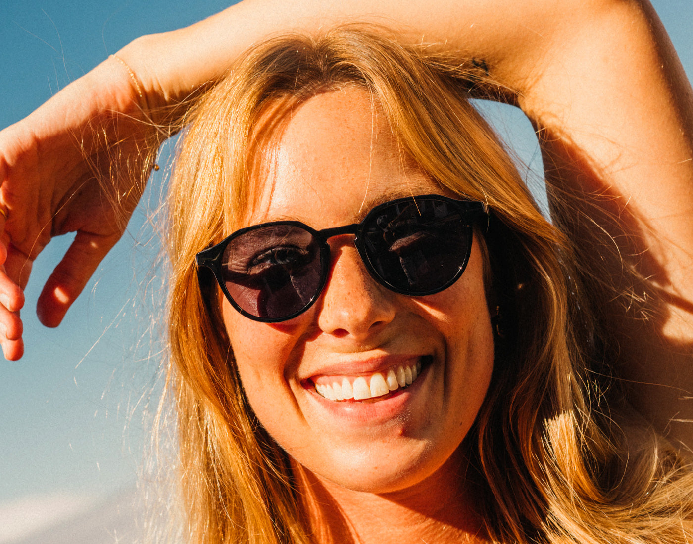 girl smiling wearing sunski vallarta sunglasses