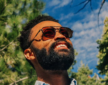 man looking up at the sky wearing sunski estero sunglasses