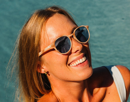 girl laughing by the pool wearing sunski vallarta sunglasses