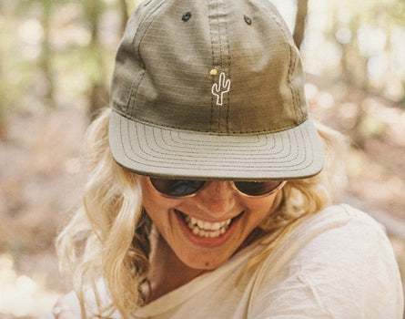girl looking down laughing wearing sunski friendly cactus hat