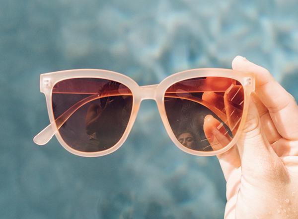 sunski camina hand holding in front of pool