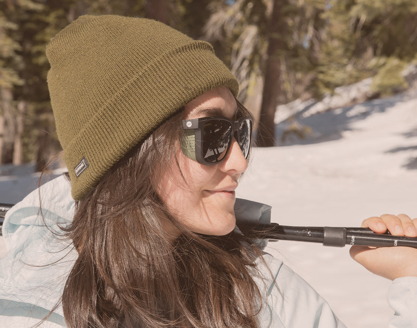 side profile of girl holding ski poles wearing sunski couloir sunglasses