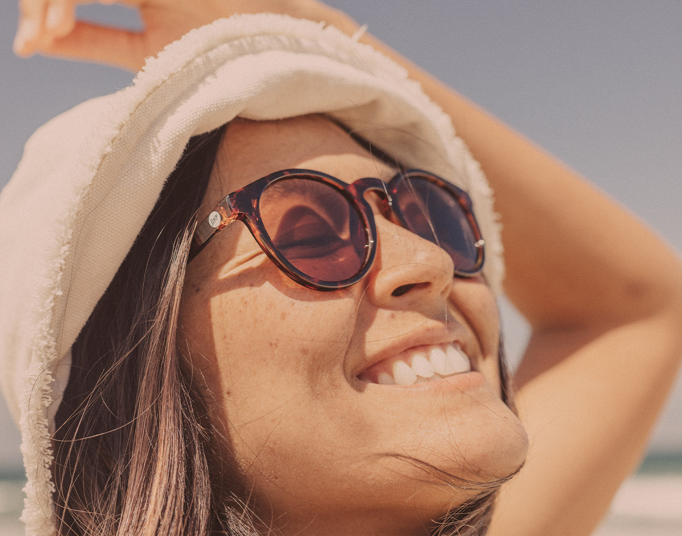 close up of girl basking and smiling wearing sunski dipsea sunglasses