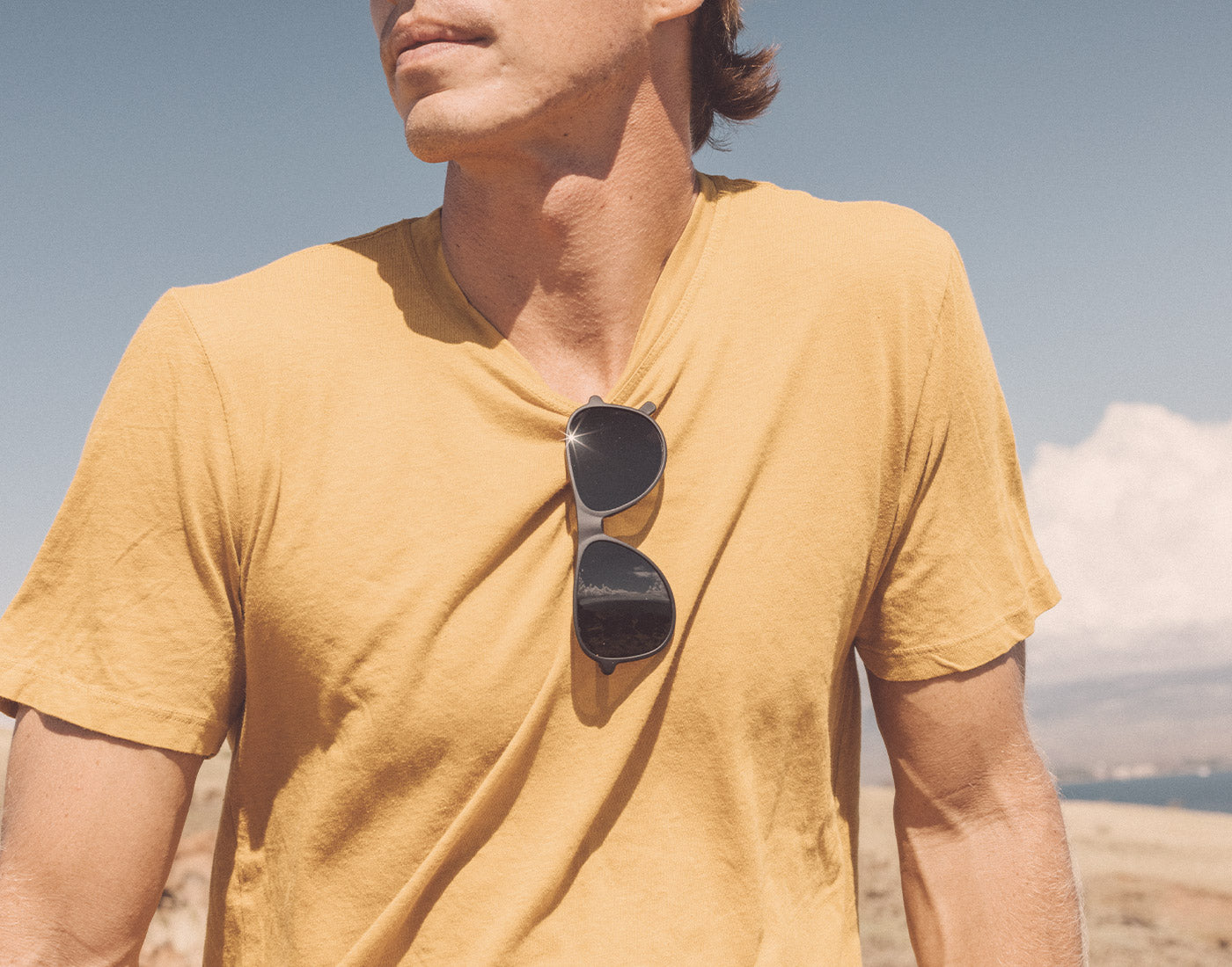 person with sunski foxtrot sunglasses haging on shirt collar