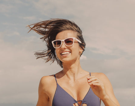 girl running and smiling wearing sunski headland sunglasses