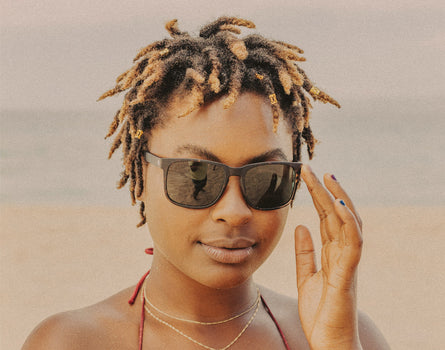 woman wearing sunski kiva sunglasses with hand holding them