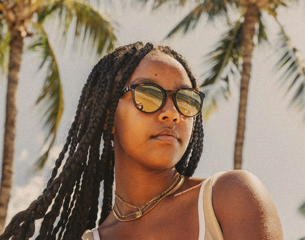 girl in tropical setting wearing sunski makani sunglasses