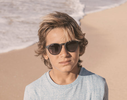 boy on the beach wearing sunski mini dipsea sunglasses