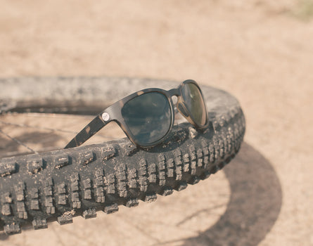 sunski topeka sunglasses resting on bike tire