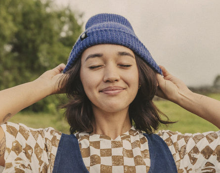 girl smiling wearing sunski shoulder season beanie