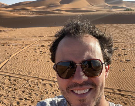 Man wearing sunglasses with desert landscape in the background