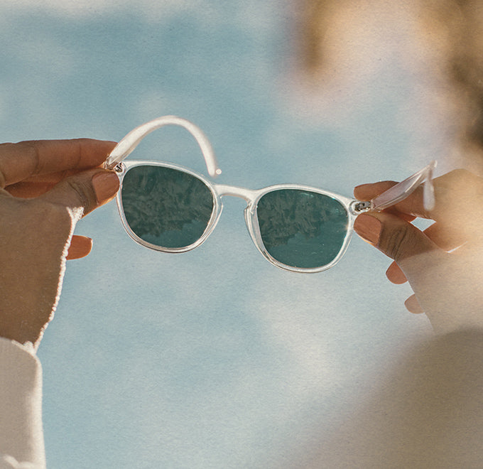 hands holding sunski yuba clear sunglasses