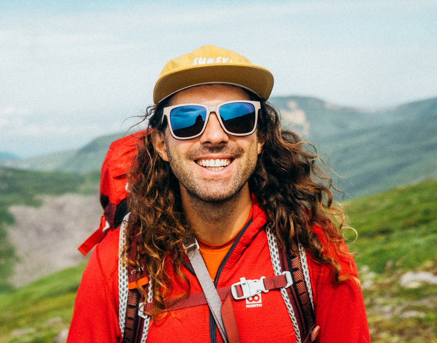 man backpacking in sunski couloir dune galaxy and sunski team hat