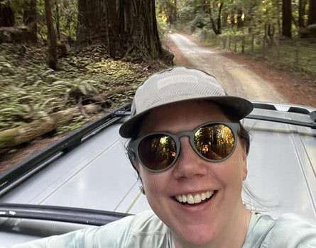 Person taking a selfie in a car on a forest road