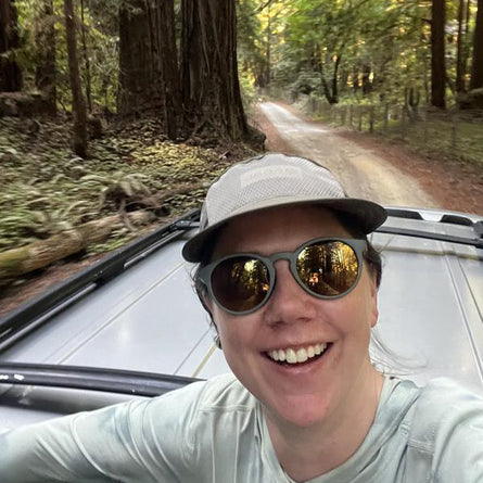 Person taking a selfie in a car on a forest road