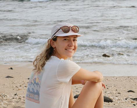 Woman sitting on a beach with ocean waves in the background