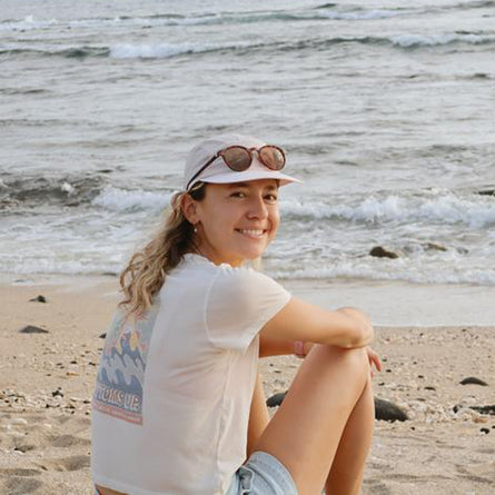 Woman sitting on a beach with ocean waves in the background