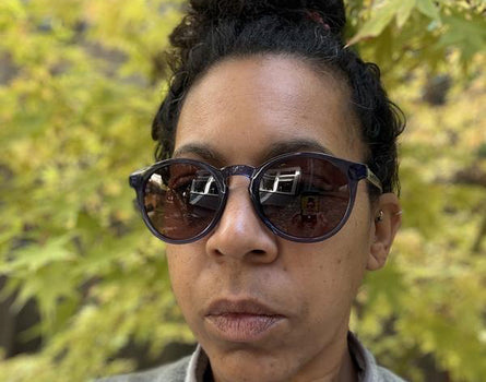 Person wearing sunglasses with a blurred natural background