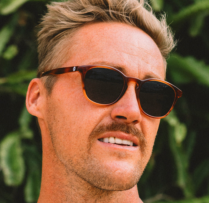close up of guy with mustache wearing sunski sunglasses
