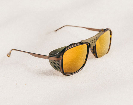 Sunglasses with gold lenses and brown frame on a white background