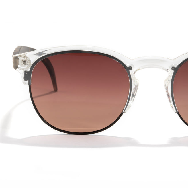 Sunglasses with clear frame and brown gradient lenses on a white background