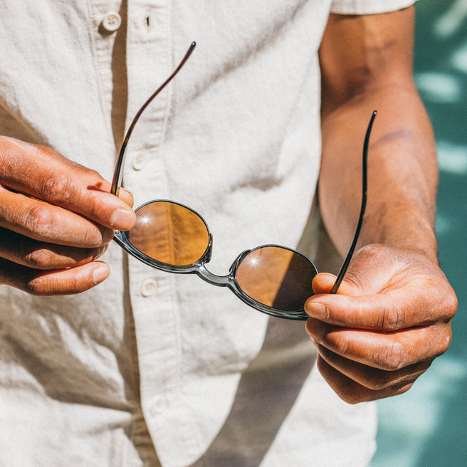 man holding tortoise shell sunglasses