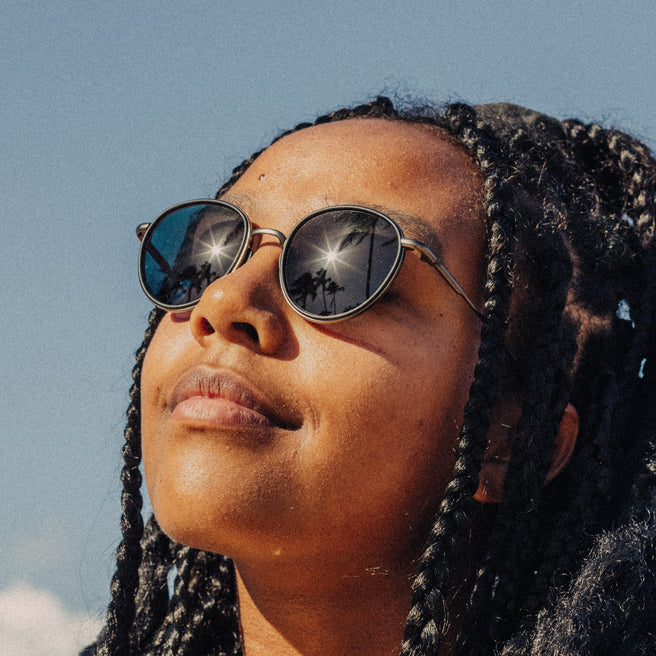 Person wearing sunglasses with a clear blue sky background