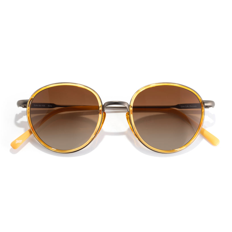 Round sunglasses with gold frames and brown lenses on a white background