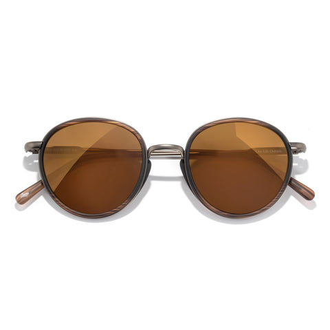 Round sunglasses with brown lenses and gold frames on a white background