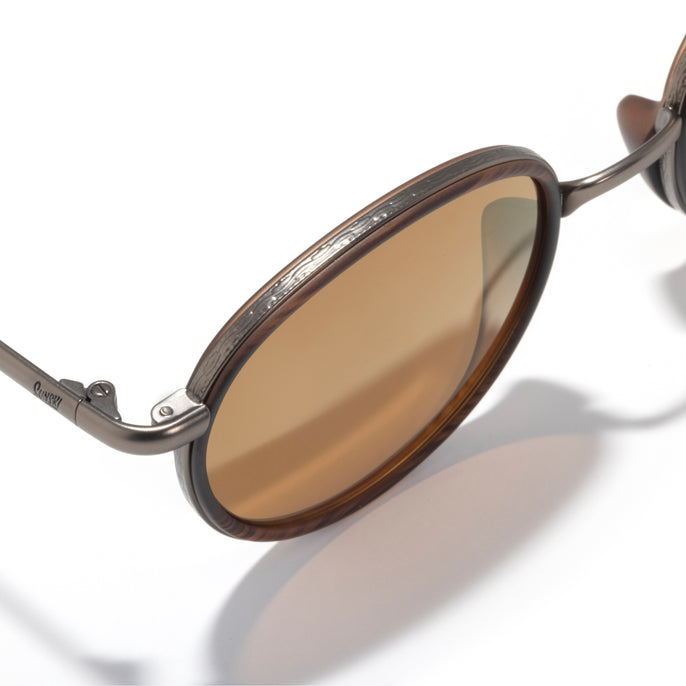 Brown sunglasses with a reflective lens on a white background