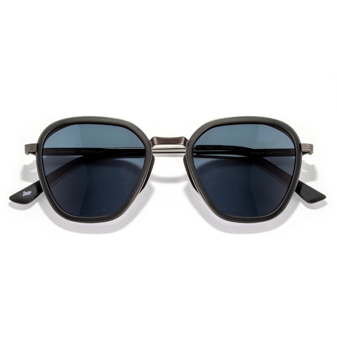 Sunglasses with dark lenses and gold frame on a white background