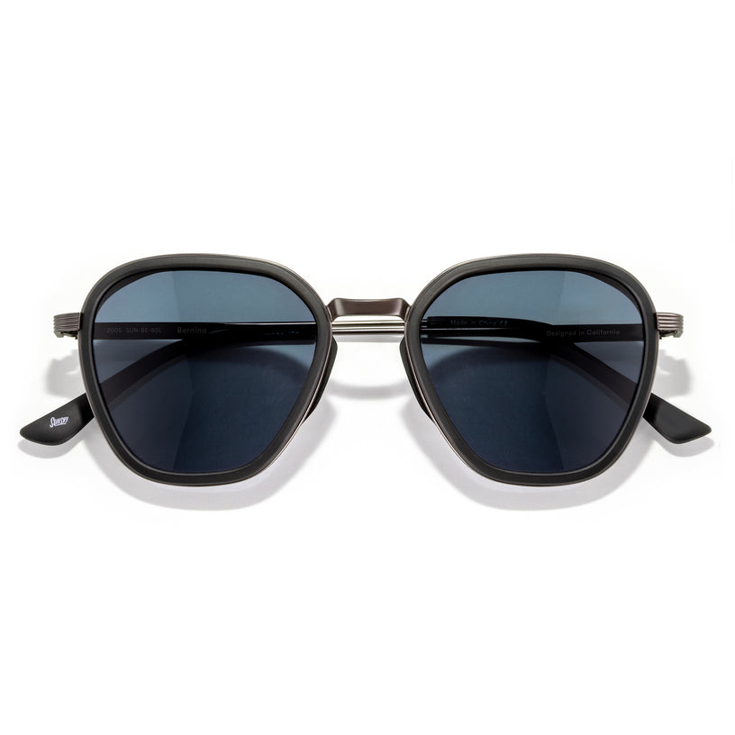 Sunglasses with dark lenses and gold frame on a white background