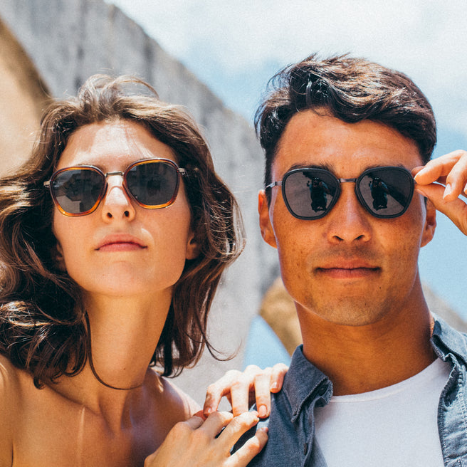 Bernina - Black Slate - Two people wearing sunglasses outdoors with a clear sky background