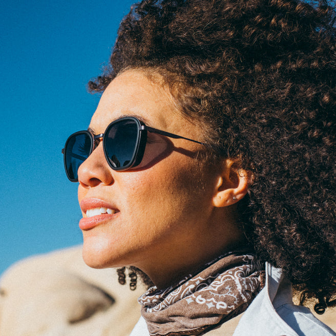 Bernina - Black Slate - Woman wearing sunglasses with a clear blue sky background