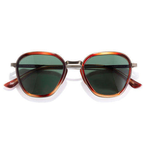 Sunglasses with tortoiseshell frame and green lenses on a white background