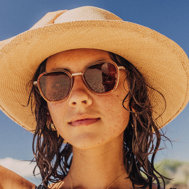 Bernina - Desert Amber - Person wearing a straw hat and sunglasses with a clear blue sky background