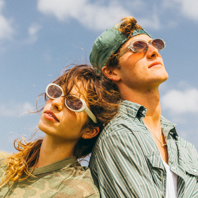 guy and gal wearing hats and sunglasses with blue sky