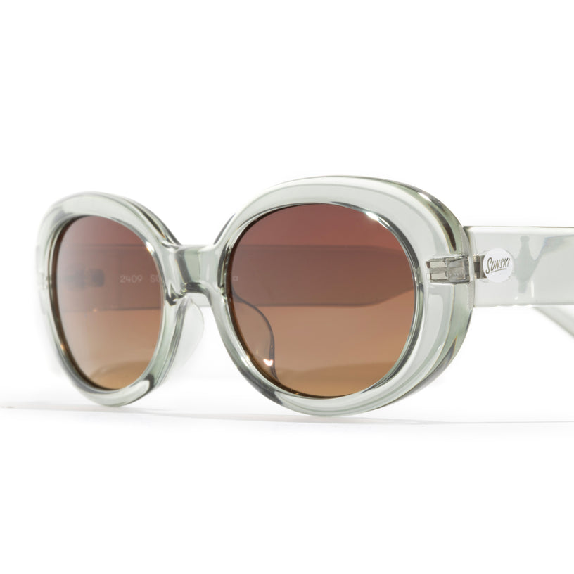 Round sunglasses with clear frame and brown lenses on a white background