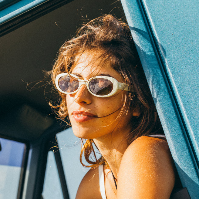 woman wearing white sunglasses in a blue vehicle