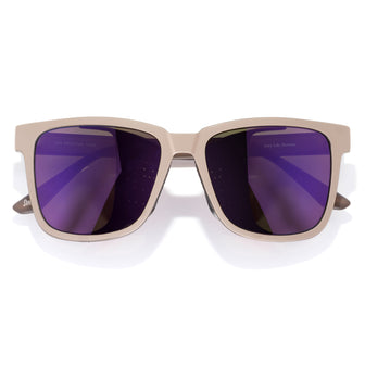 Beige sunglasses with purple lenses on a white background