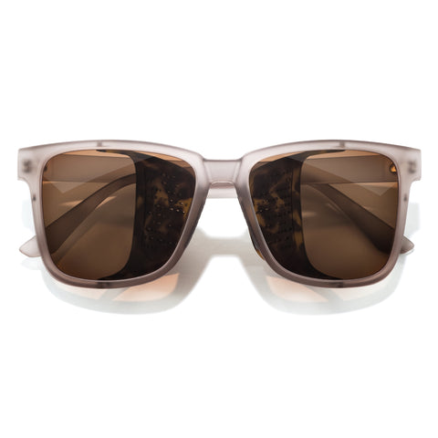 Sunglasses with brown lenses and beige frame on a white background