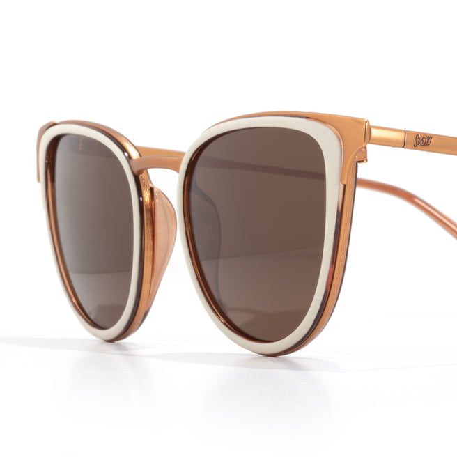 Sunglasses with brown lenses and rose gold frame on a white background