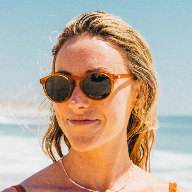 Woman wearing sunglasses with a beach background