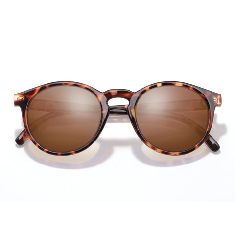 Sunglasses with tortoiseshell frame and brown lenses on a white background