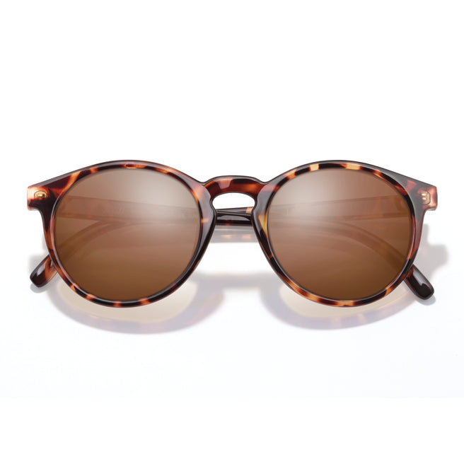 Sunglasses with tortoiseshell frame and brown lenses on a white background